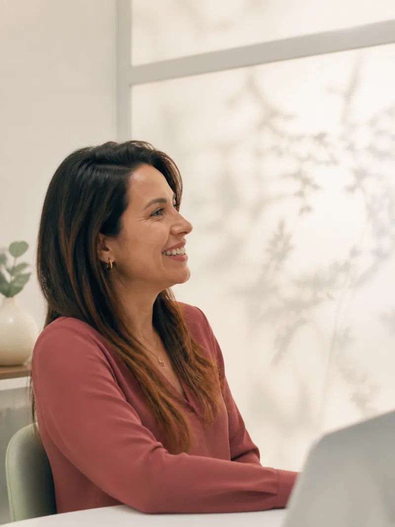 Paciente adulta sorrindo durante uma conversa em ambiente odontológico